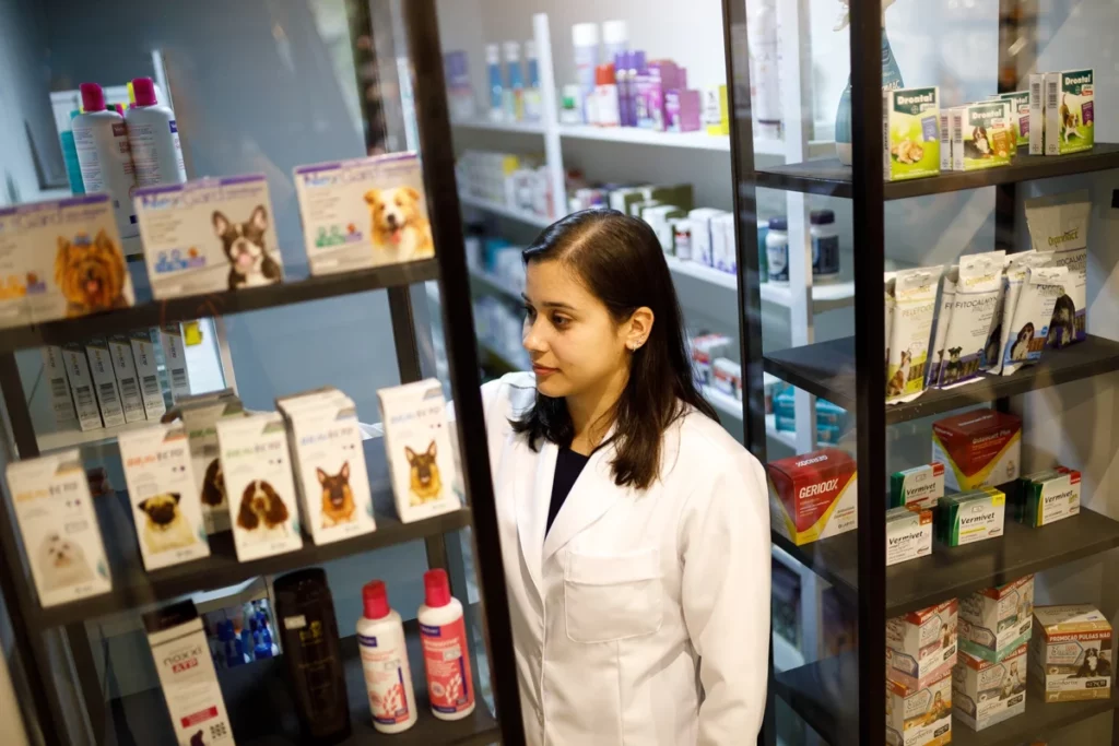 Como vender no iFood: Uma veterinária, vestindo um jaleco, está entre prateleiras com remédios para animais.